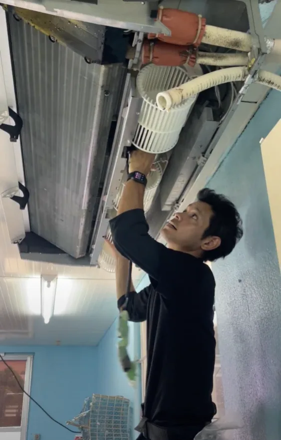 業務用エアコンの内部で作業するBCサービス代表