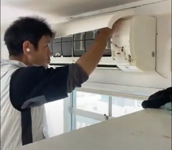 壁掛けエアコンのカバーを開いて点検・清掃作業をするBCサービス代表